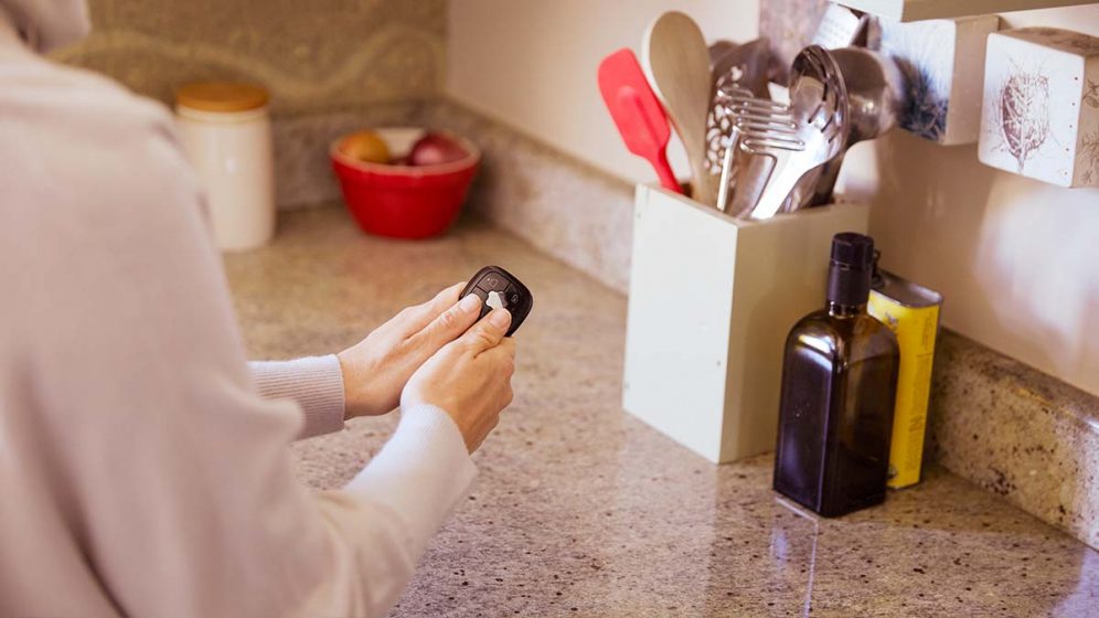 una cliente usa il telecomando antifurto di verisure per inserire l'allarme a casa sua