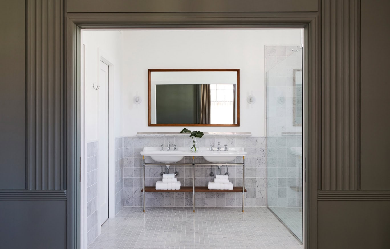 The loft-like Wall St Suite at Hotel Kinsley is complete with original ornate moldings and marble tile bathroom with soaking tub, rain shower and two sinks.