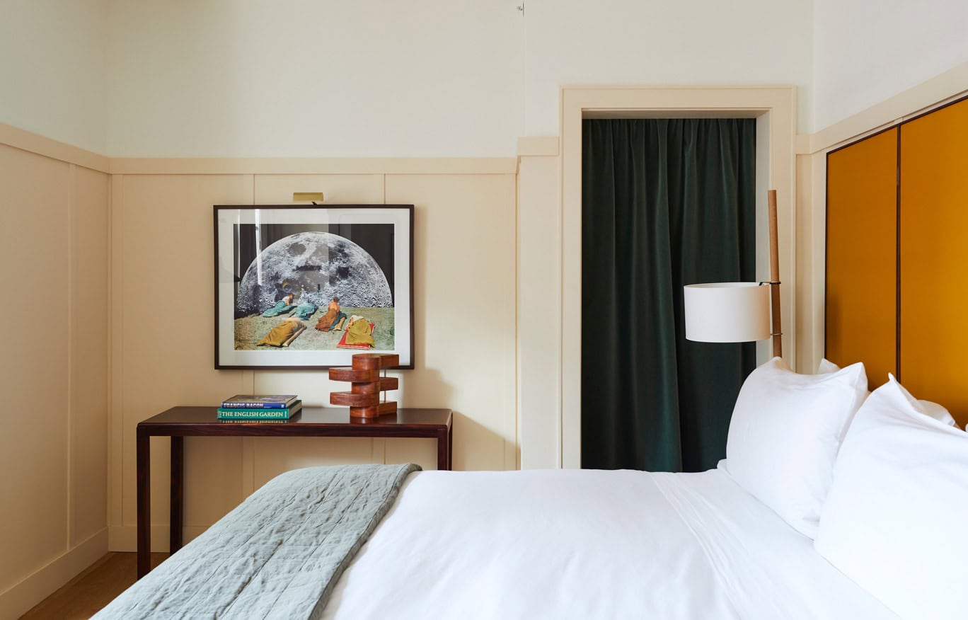 A bright, minimalist Standard King Guest Room at Hotel Kinsley's 301 Wall Street location. Each room features a king bed, built-in desk, armoire closet, marble tile bathroom, and all of the standard room amenities.