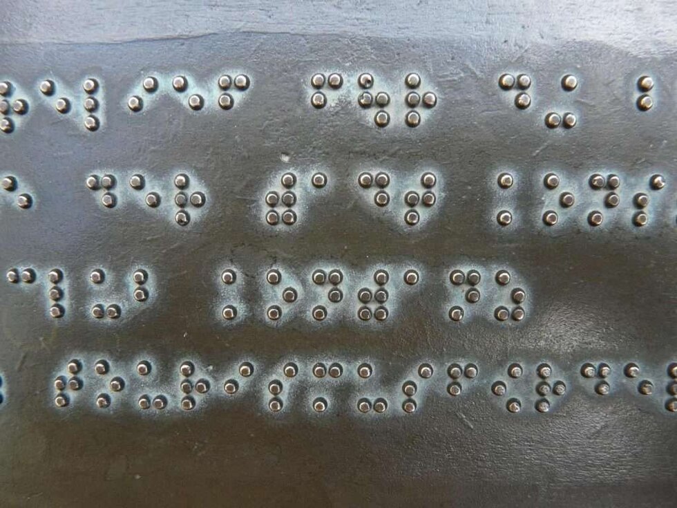 Braille letters on a metal sheet for our language spotlight.