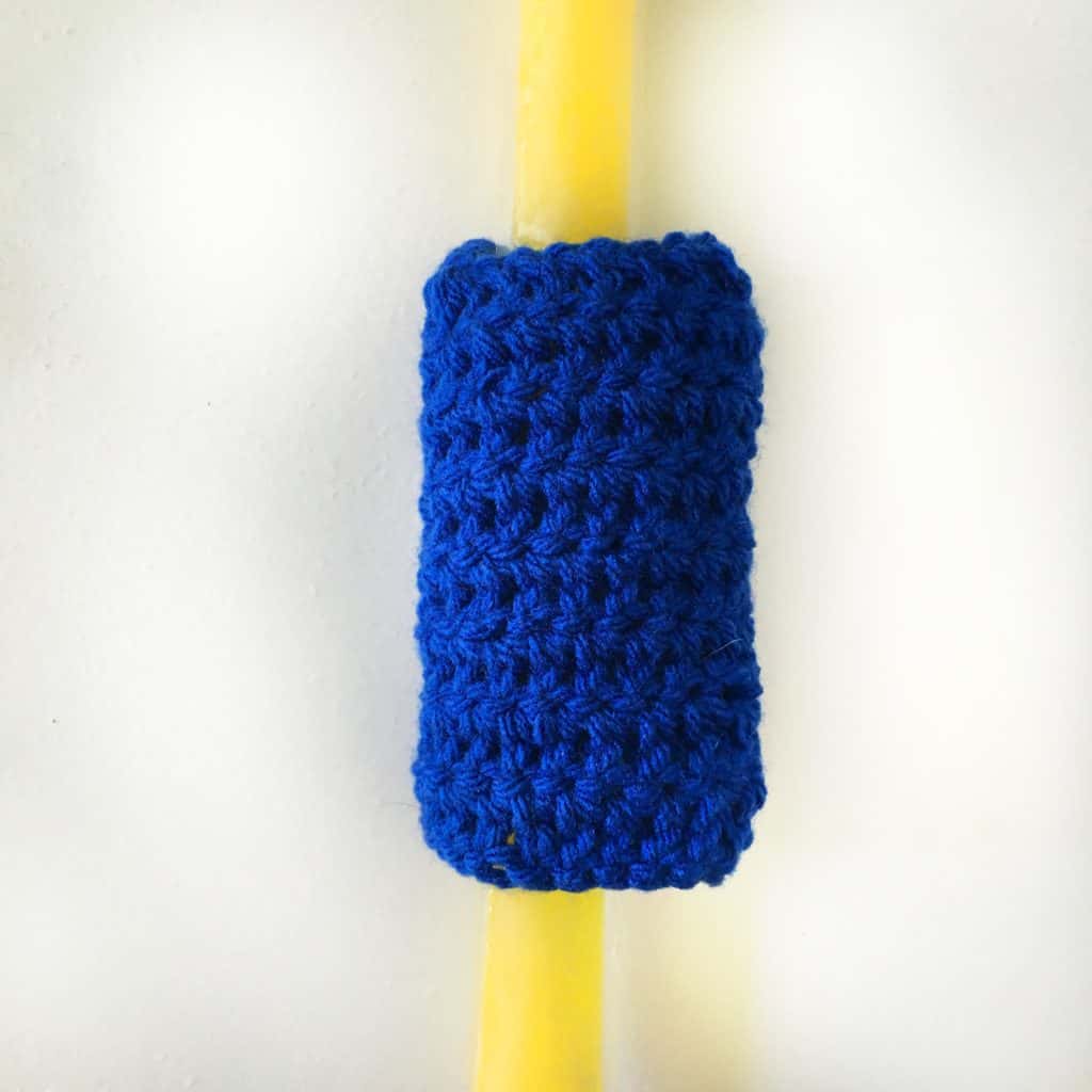 yellow otter pop with a blue ice pop cozy on it.
