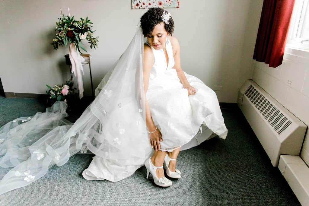 bride putting on her wedding shoes