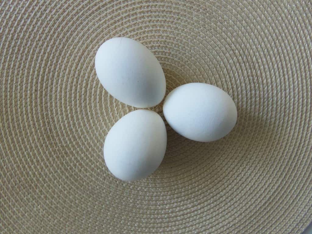 three eggs pointing together on a placemat