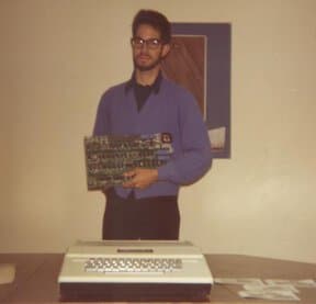 Bill Fernandez holds an Apple I, with an Apple II on the desk. Photo courtesy of Bill Fernandez