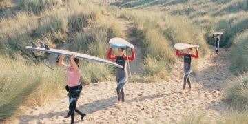 Carrying surfboards through the heather in wales
