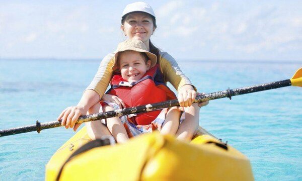 A single parent kayaking with her child in the caribbean sea off of riviera maya