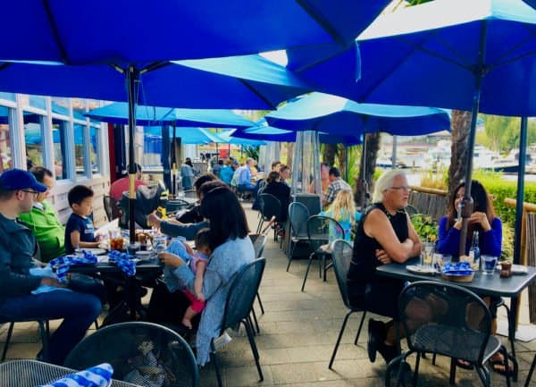 The lakeside patio with bright blue umbrellas at duke's seafood in seattle.