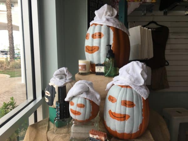 Pumpkins in facial masks decorate high cottons windows in fall.