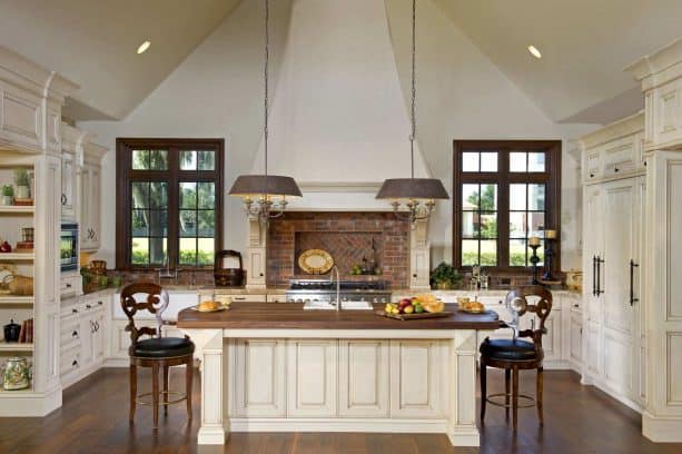 cream kitchen cabinets paired with red brick backsplash