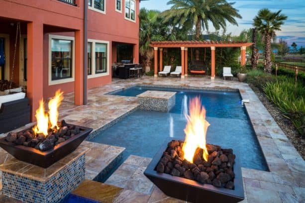 small inground pool with fire bowls features