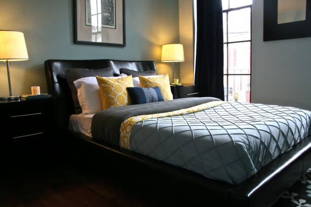 a contemporary bedroom with greyish blue walls and black curtain