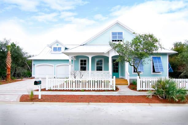 a beach-style house in light blue color with white roof