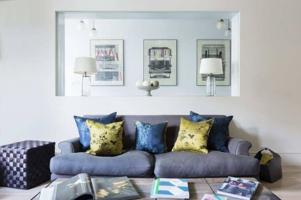 a frameless glass window between living room and hallway