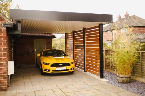 a trendy carport with a wooden privacy screen and a touch of black for boldness