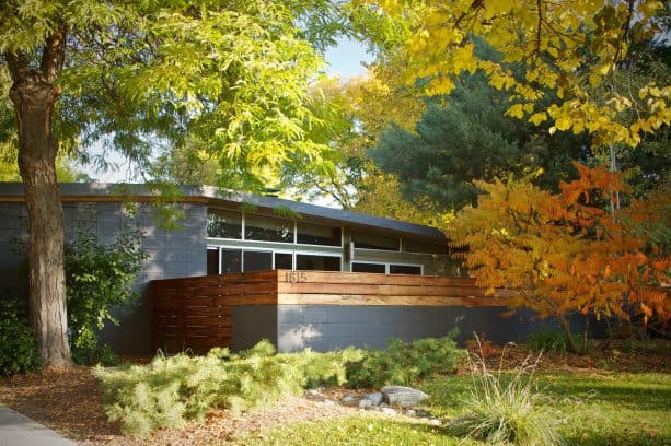 a home exterior showing a striking combination between dark grey cinder block and tigerwood walls