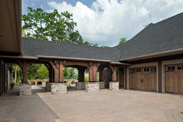the covered walkway looks gorgeous with the combination of wood and brick as the main materials