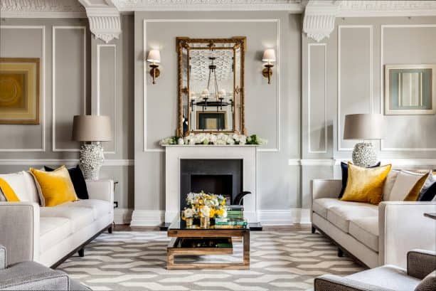 a cozy living room with warm grey tones and mustard yellow cushion