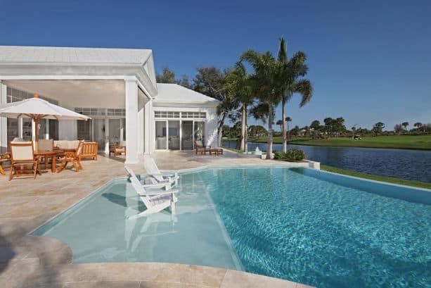 small tropical inground pool with tanning ledge