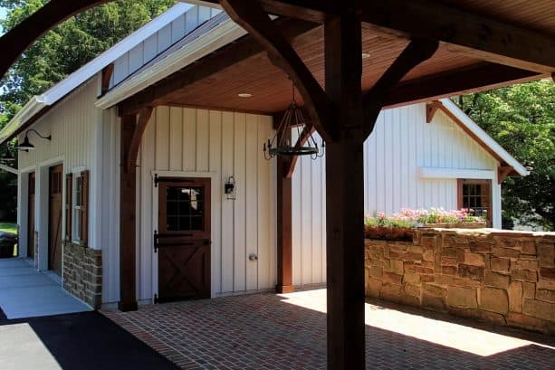 the walkway looks gorgeous because of the stained wood posts and ceiling and also brick floor