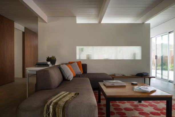 a midcentury living room with long indoor frosted glass window