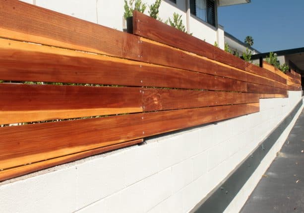 cinder block and wood fencing on sloppy land