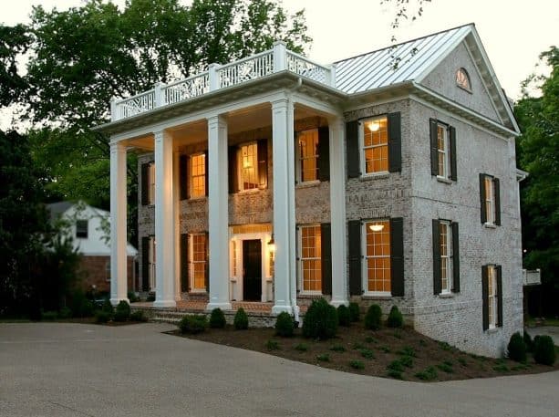 a whitewashed brick house with white metal roof