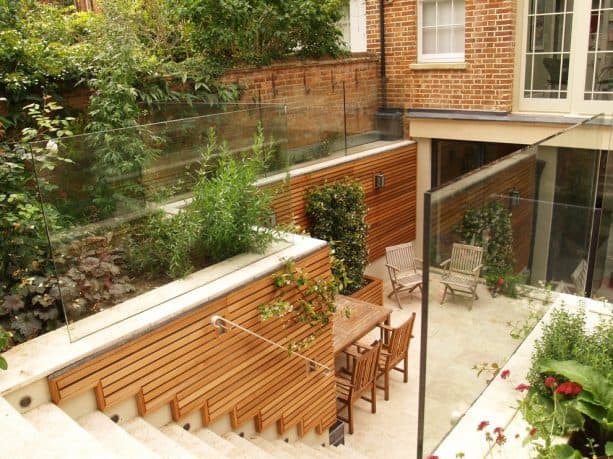 a sunken walkout basement patio with cedar trellis on each side