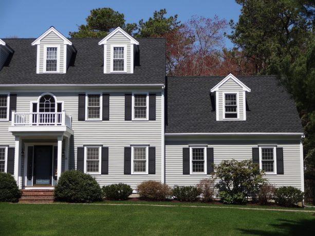 a light grey traditional home exterior with charcoal grey roof