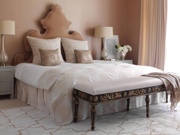 a contemporary bedroom with tan headboard and soft pink walls