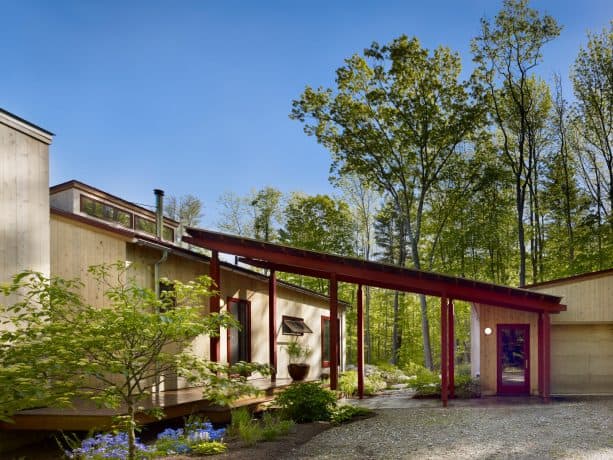 a covered garage walkway look trendy because of the slide design and the stained wood material