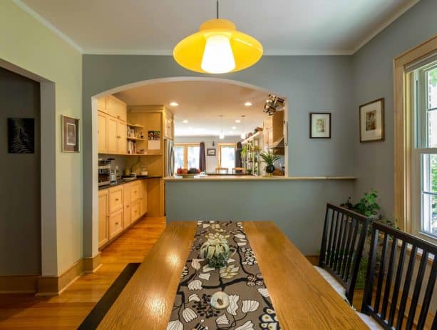 a half wall with top in an eclectic dining room and kitchen