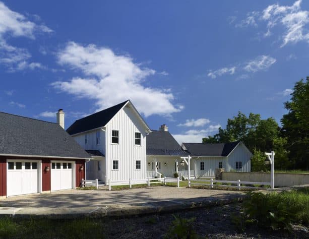 an elegant farmhouse exterior with White Dove OC-17 and Cottage Red PM-15 paint color combination