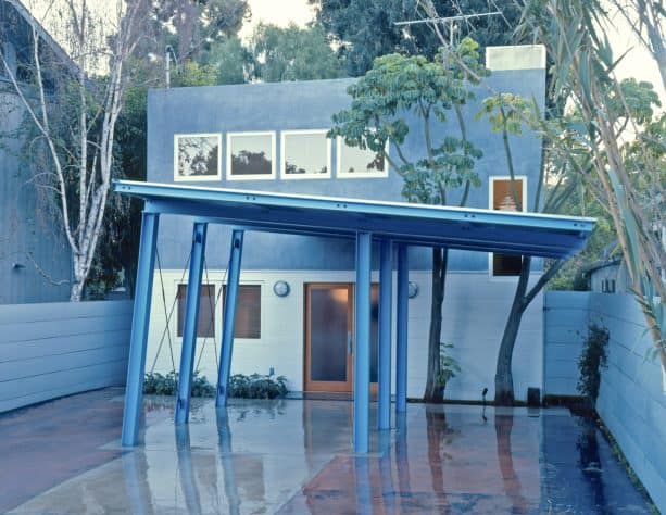 a unique blue steel carport with coordinating color with the exterior color scheme