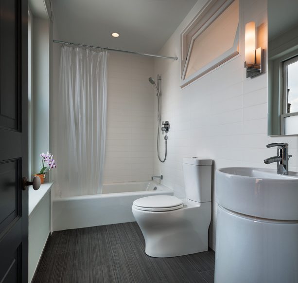 a contemporary bathroom with indoor tilting window on the top part of the wall