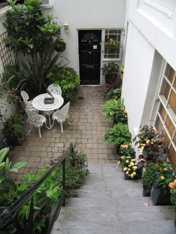 a transitional walkout basement patio with green garden