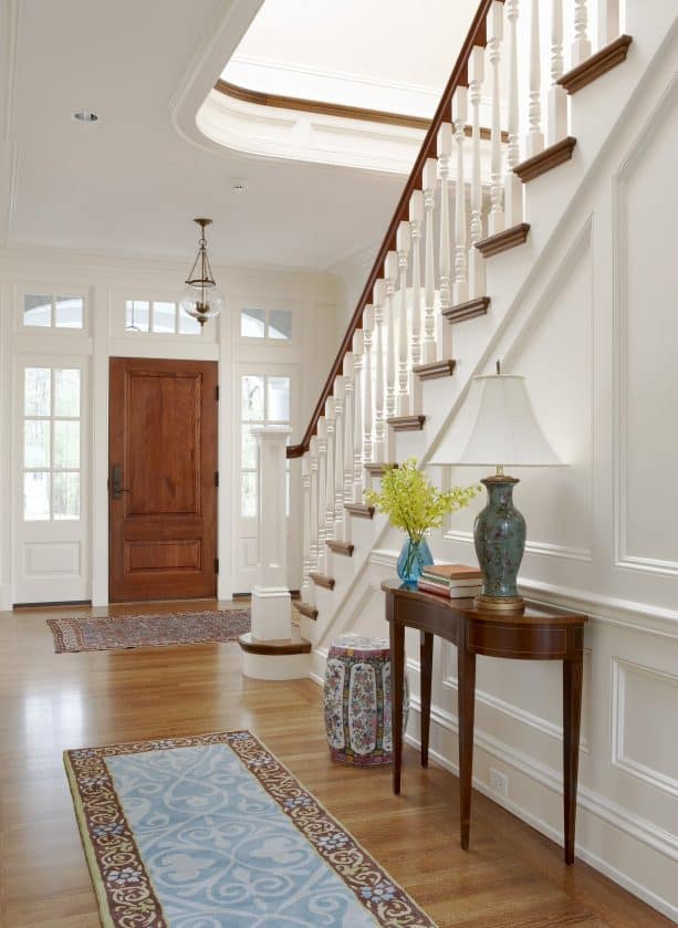 a wood door and white trim that look matching with the staircase design
