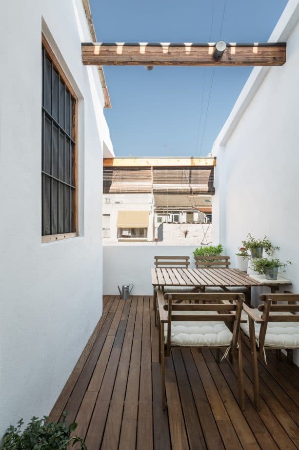 balcony with an outdoor dining table set and bamboo blinds