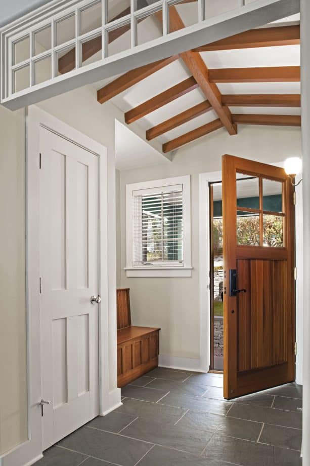 a medium tone wood door with white trim in a transitional entry