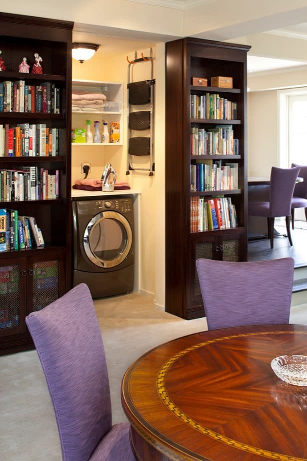 a laundry closet hidden behind a bookshelf