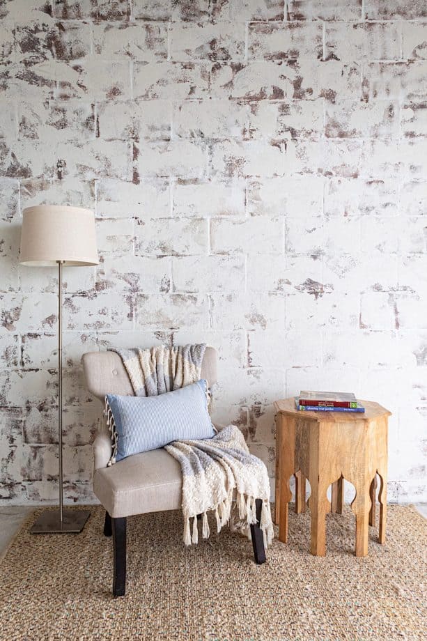 the mixture of off-white, maroon, and off-black paint colors on a cinder block wall
