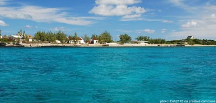 The white cottages and small beaches of historic cockburn harbor in south caicos, as seen from the water.