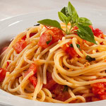 Spaghetti ao alho e óleo com pedaços de tomate fresco e folhas de manjericão