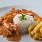 Strogonoff de Frango, acompanhado de arroz e batatas fritas.