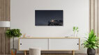 Mockup Wall art of a winter mountain village with festive lights under a dark sky