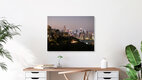 Mockup Photo art by Inflight Galerie: view of a city skyline at night with glowing lights.