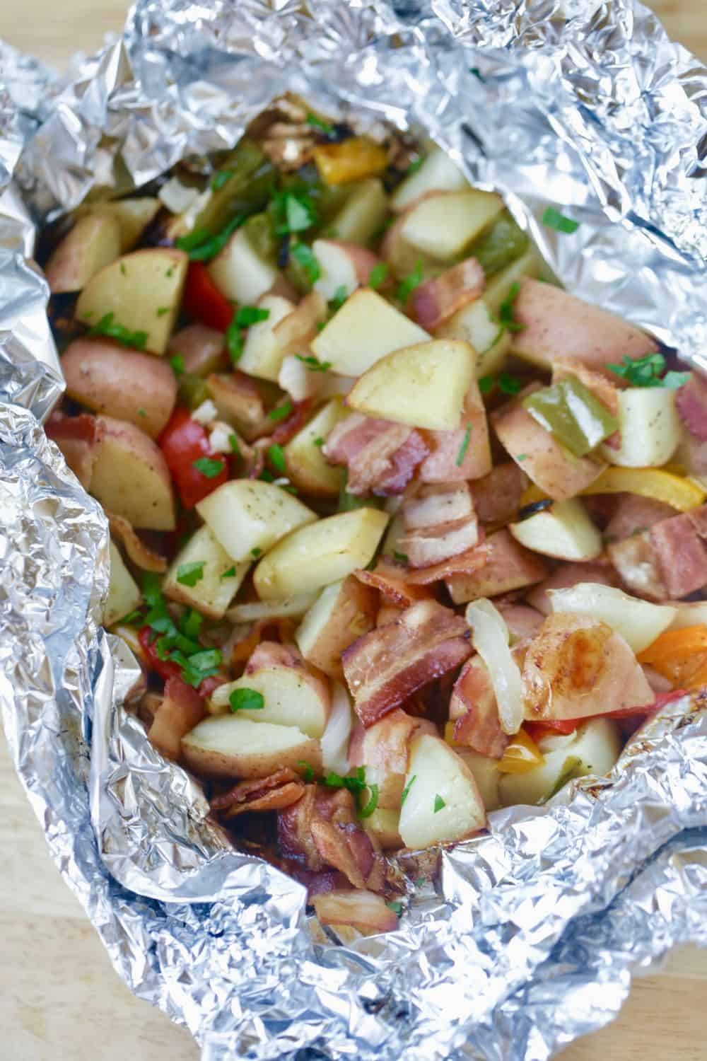 Fire up the grill and make this Potato And Bacon Foil Packets recipe. This easy grilled side dish is a perfect summer recipe or camping recipe. And it has bacon in it! #foilpackets #potatoandbaconfoilpacket #campingrecipe #grillingrecipe #Ad #BTBGrillingRecipes #IC