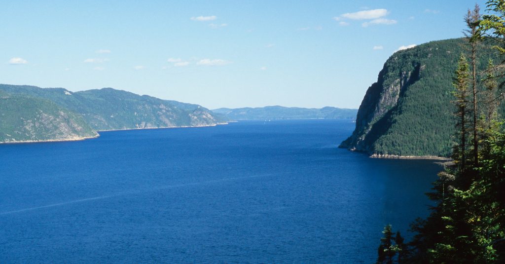 Wide Saguenay Fjord with cliffs rising up to meet the blue skies makes this one of 20 best places to visit in 2020.