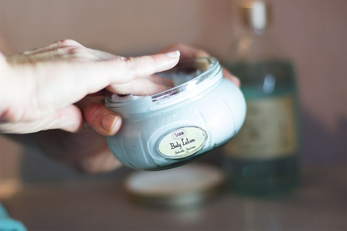 Hand dipping into a jar of Jasmine Sabon Body Cream