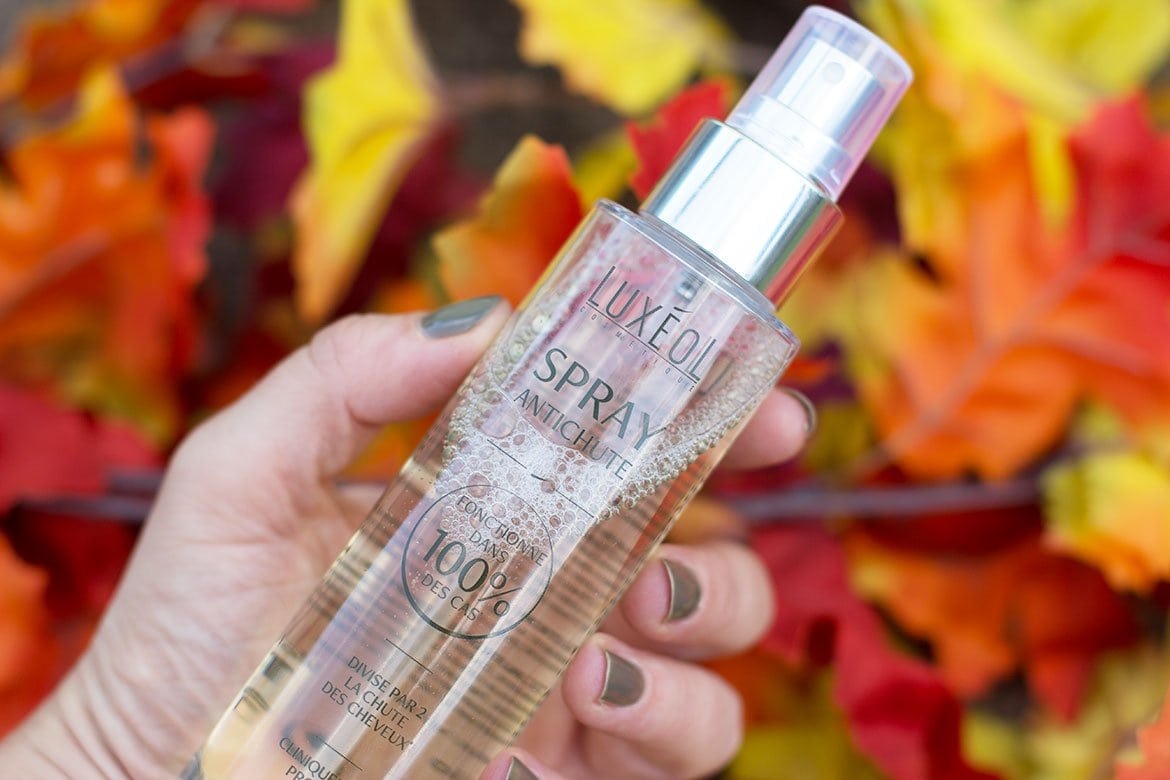 Hand holding Luxéol hair loss spray