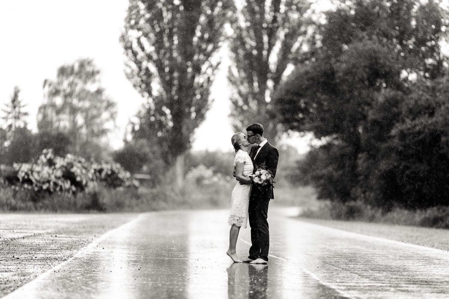 Kissing in the Rain Brautpaar küsst sich barfuß im strömenden Regen Hochzeitsfotograf Andreas Pöcking aus Erfurt